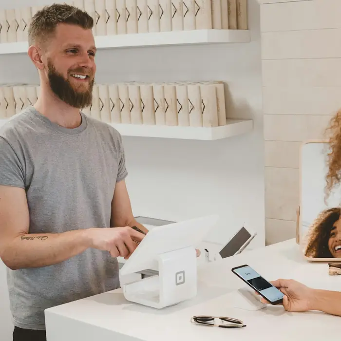 Shop owner serving a customer at the till